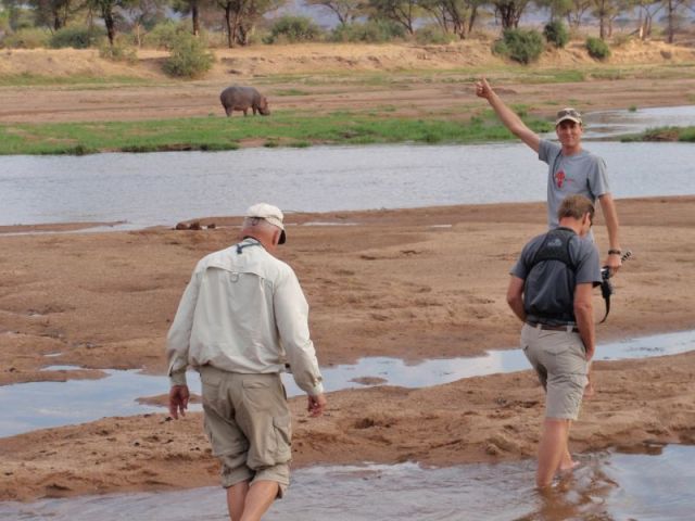 Wading in the Ruaha River with a grazing hippo in the background. Paul's photo