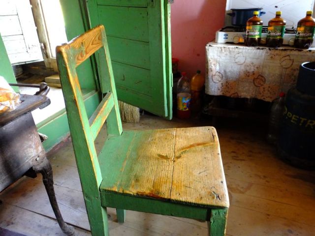 Besides the neat old chair notice the stove in the background with the beer sitting In front of it.