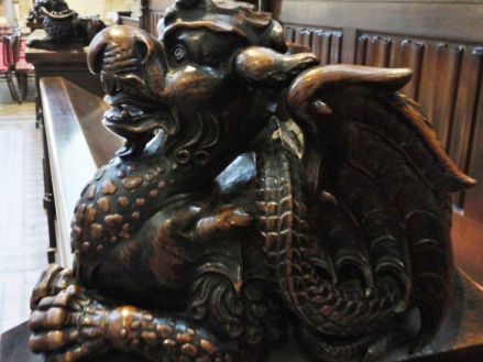 Close-up of the dragon on the end of one of the pews in the cathedral
